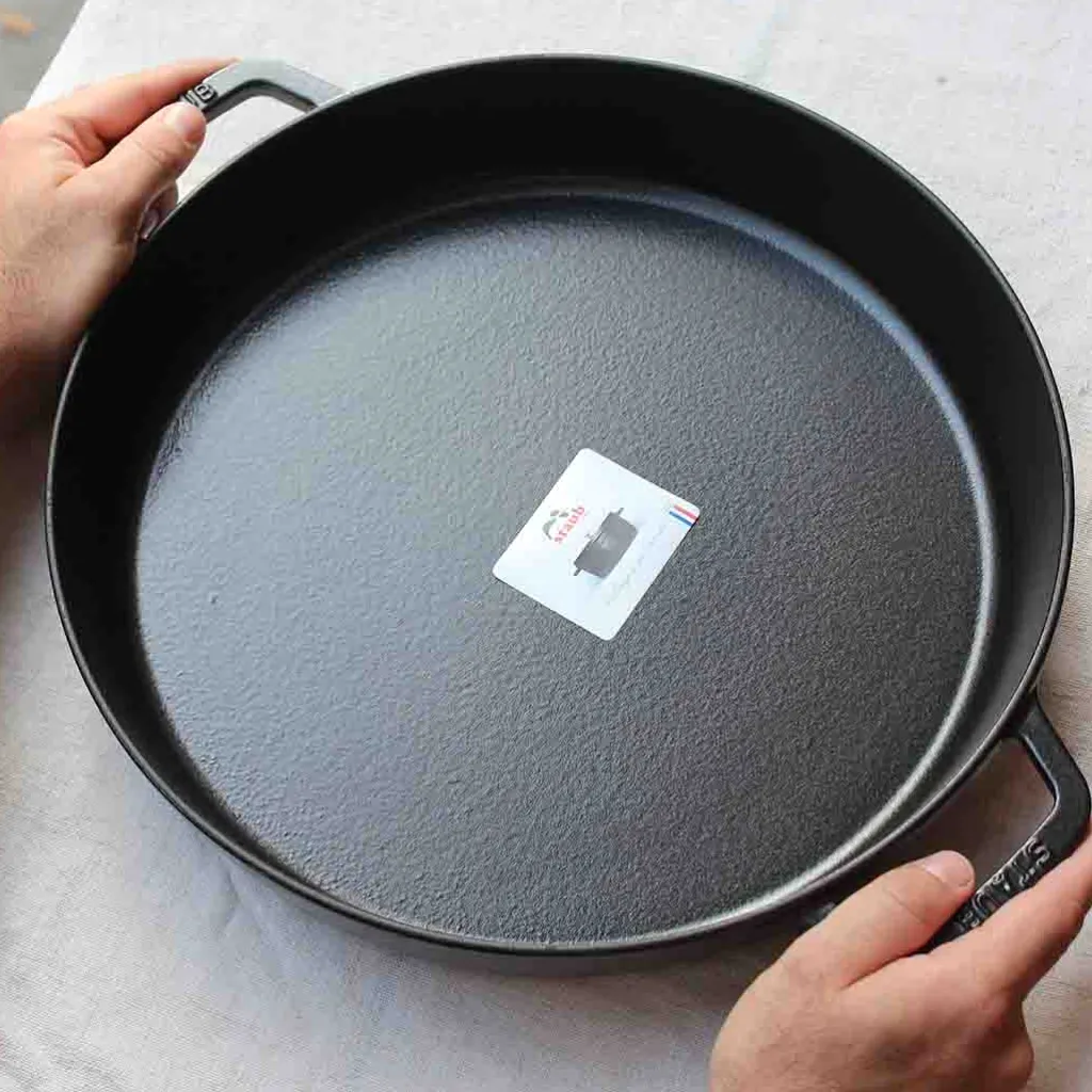 Staub Grand plat rond à anses en fonte noire